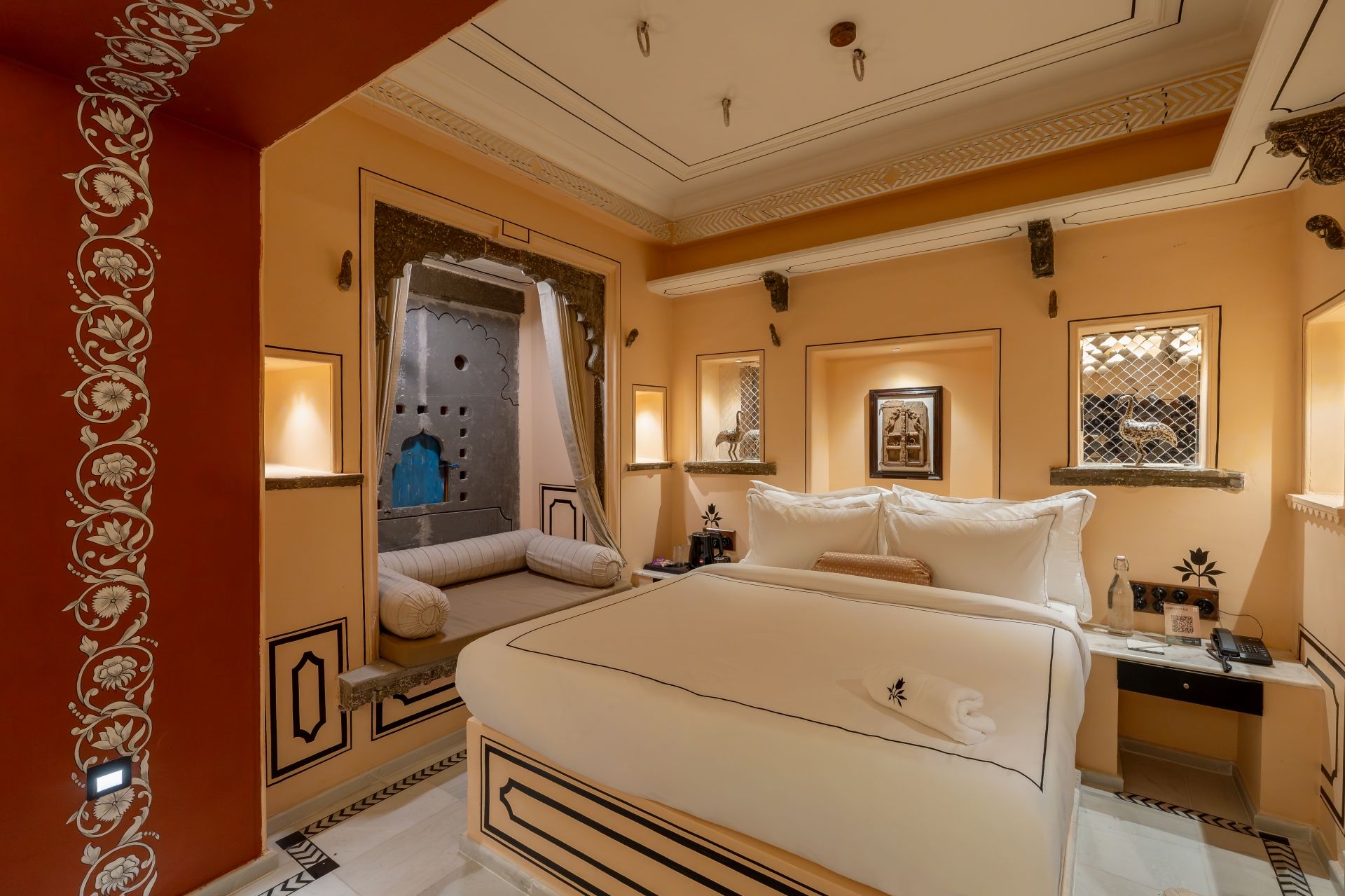 Een hotelkamer met een groot bed, een bureau met telefoon en een raam met uitzicht.