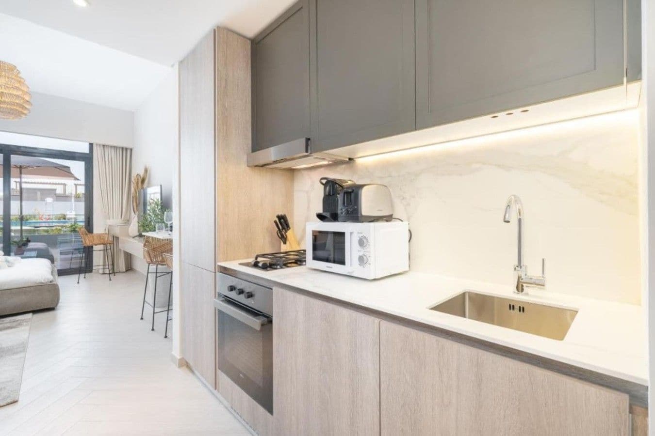 Une cuisine moderne équipée d’un four à micro-ondes, d’une cuisinière et d’un évier intégrés.