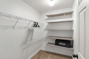 A closet with open shelving, a hanging rod, and a door with a doorknob.