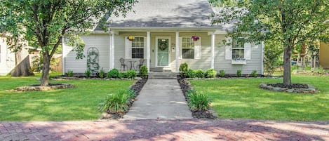 A two-story house with a front porch, a front door, and a mailbox.