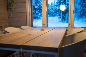Ein Holztisch mit Stühlen in einem Raum mit großen Fenstern.