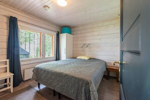 A bedroom with a bed, a window, a wardrobe, and a door.