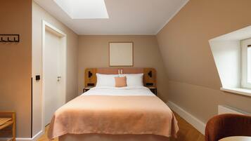 Un dormitorio con una cama, una mesita de noche, una silla y un ventanal.