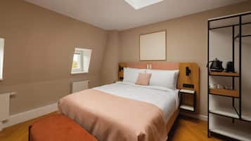 Ein Schlafzimmer mit einem Bett, einem Nachttisch, einem Heizkörper, einem Fenster, einem Regal mit Küchenutensilien und einer Bank.