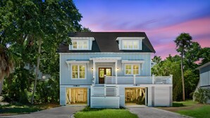 A two-story house with a front porch, a garage, and a driveway. - Private Pool|Wild Dunes|4 Beds (Isle of Palms)