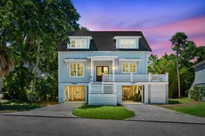 A two-story house with a front porch, a garage, and a driveway. - Private Pool|Wild Dunes|4 Beds (Isle of Palms)