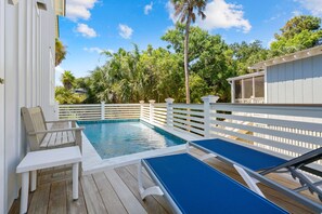 A pool area with a wooden deck, white railings, and a covered seating area. - Private Pool|Wild Dunes|4 Beds (Isle of Palms)