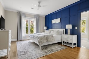 A bedroom with a bed, nightstands, a dresser, a ceiling fan, and a window with curtains. - Private Pool|Wild Dunes|4 Beds (Isle of Palms)