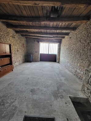 A room with a stone wall, a wooden ceiling, and a large window.
