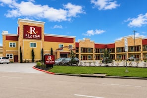 A Red Star Inn & Suites hotel with a clear sky.