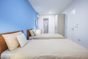Ein Hotelzimmer mit zwei Betten, einer Dusche und einem Kleiderschrank.
