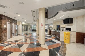 A hotel lobby with a check-in counter, a reception desk, and a patterned floor. - Bluehorizonbenalmadena Apartment with Pool, Private Terrace, and Wi-Fi (Benalmádena)
