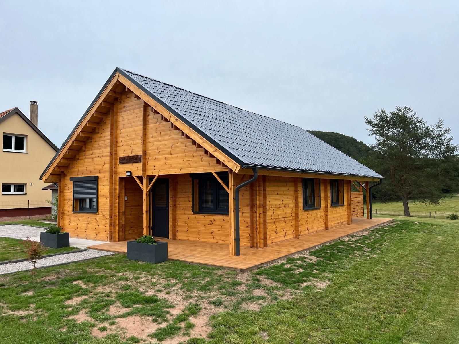 A wooden cabin with a sloped roof, a porch, and a small deck.