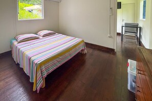 Une pièce avec un lit, une chaise et une petite table.