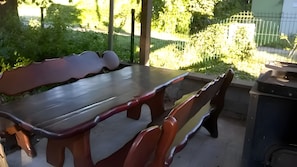 Un espace extérieur aménagé pour les repas, avec une table et des bancs.