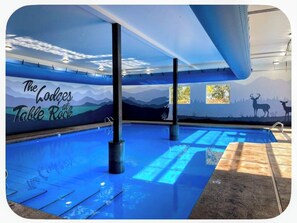 Ein Swimmingpool mit einem Wandgemälde von Bergen und Deer-Silhouetten, sowie der Text 'The Lodges at Table Rock'.