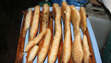 Une assiette de poisson frit à la peau croustillante, disposé sur un présentoir en bois.