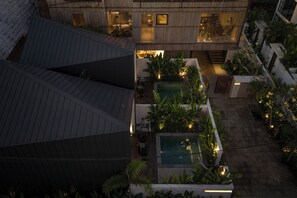 A rooftop garden with a swimming pool, seating areas, and a view of the surrounding buildings.