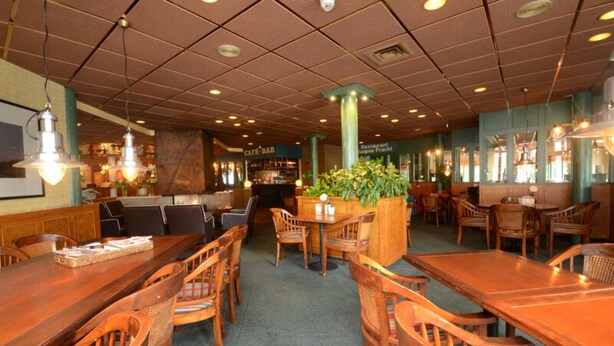 A restaurant with wooden tables and chairs, a bar area, and a green plant centerpiece. - 4 Family Apartments w/ Balcony or Terrace (Nes)