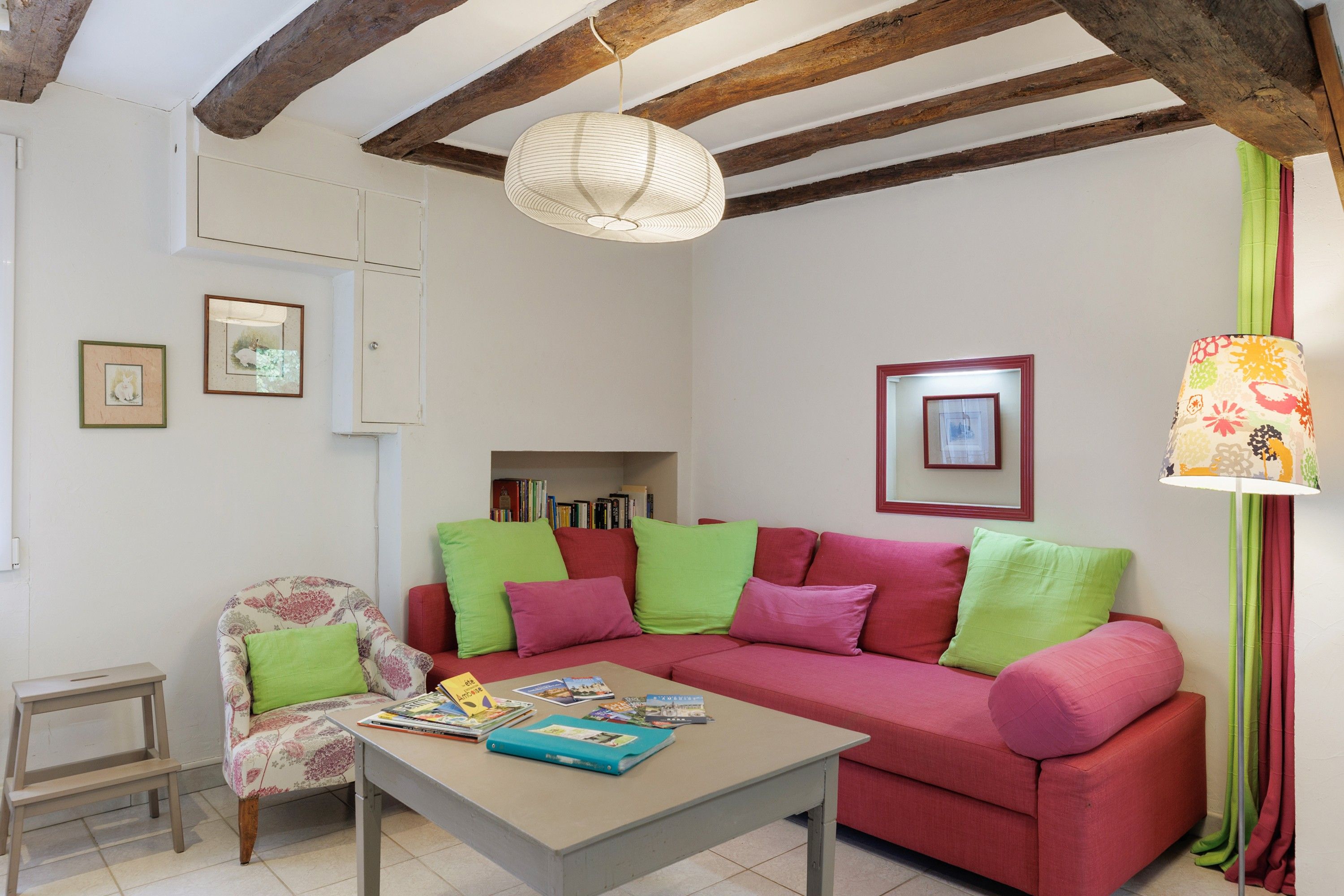 Una sala de estar con sofá, sillón y una mesa con libros.