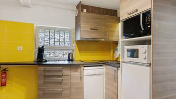 Une cuisine moderne avec des meubles de couleur jaune et blanche, un lave-vaisselle Bosch, un four à micro-ondes Samsung et une fenêtre donnant sur un paysage rocheux.