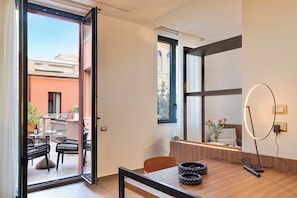 Um interior moderno com área de refeições, vista para a varanda externa e um espelho grande.