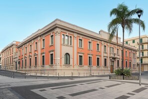 A large, historic building with a symmetrical facade, multiple windows, and a central entrance.