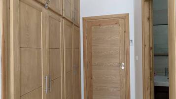 Un pasillo con armarios de madera y una puerta que da a un baño.