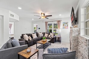 A modern living room with a sectional sofa, a coffee table, and a fireplace. - West Palm Pool Home Sleeps 10 Game Room (West Palm Beach)