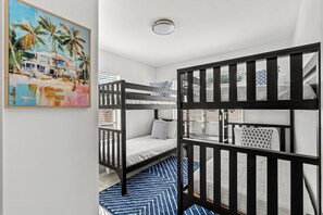 Ein Zimmer mit Etagenbetten, einem Gemälde und einem gemusterten Teppich.