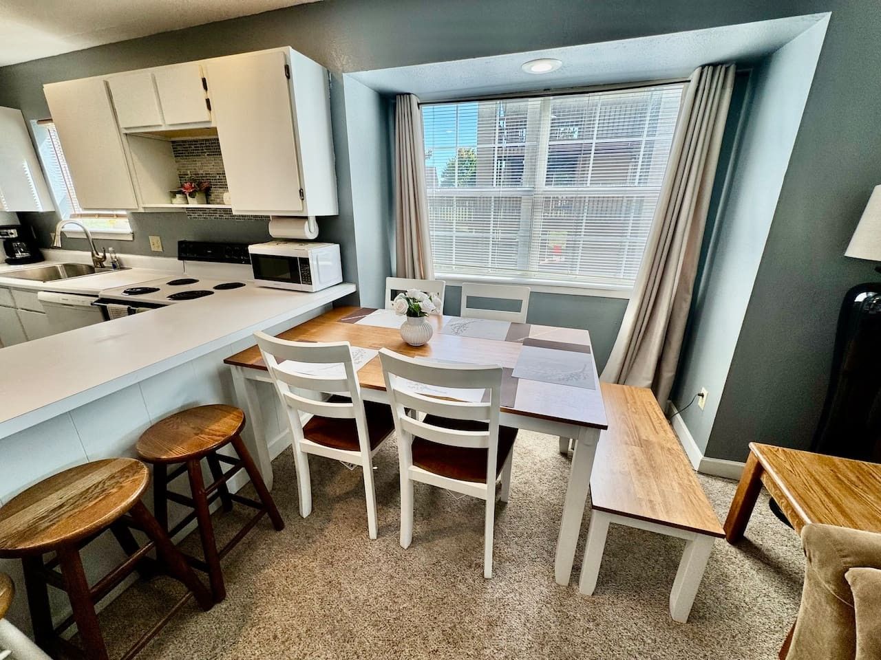 A compact kitchen with a dining area, a microwave, and a sink.