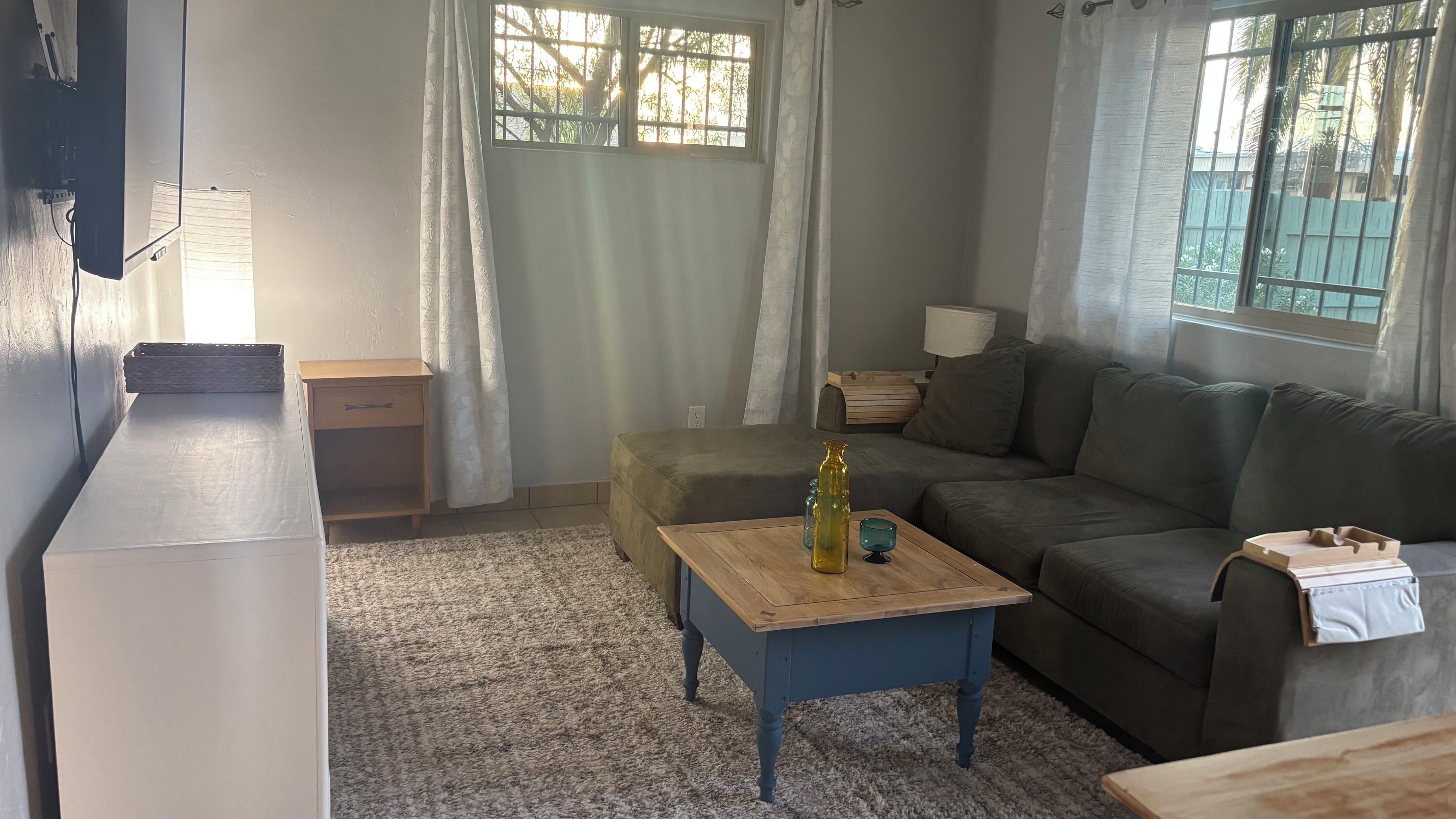 Un salon avec un canapé, une petite table, une table de chevet et une lampe.