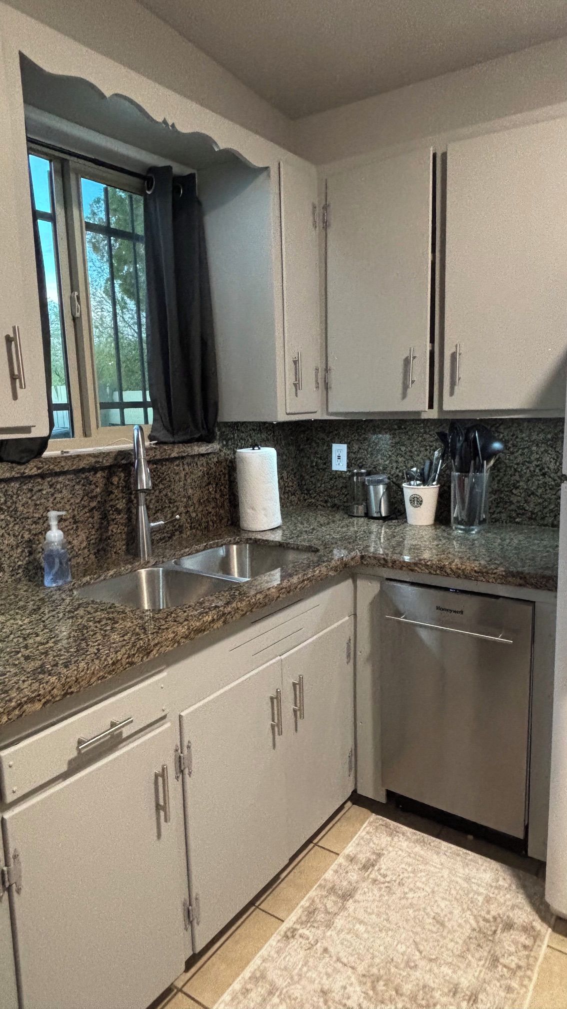 A kitchen with granite countertops, stainless steel appliances, and white cabinets.