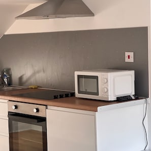 A kitchen with a microwave, a stove, and a sink.