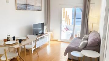 Una habitación moderna con cama, escritorio, televisión y balcón con vistas.