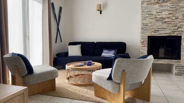 A modern living room with a dark blue sofa, two armchairs, a coffee table, and a fireplace. - Kerlevenan House: A Peaceful Haven in the Heart of the Rhuys Peninsula (Sarzeau)