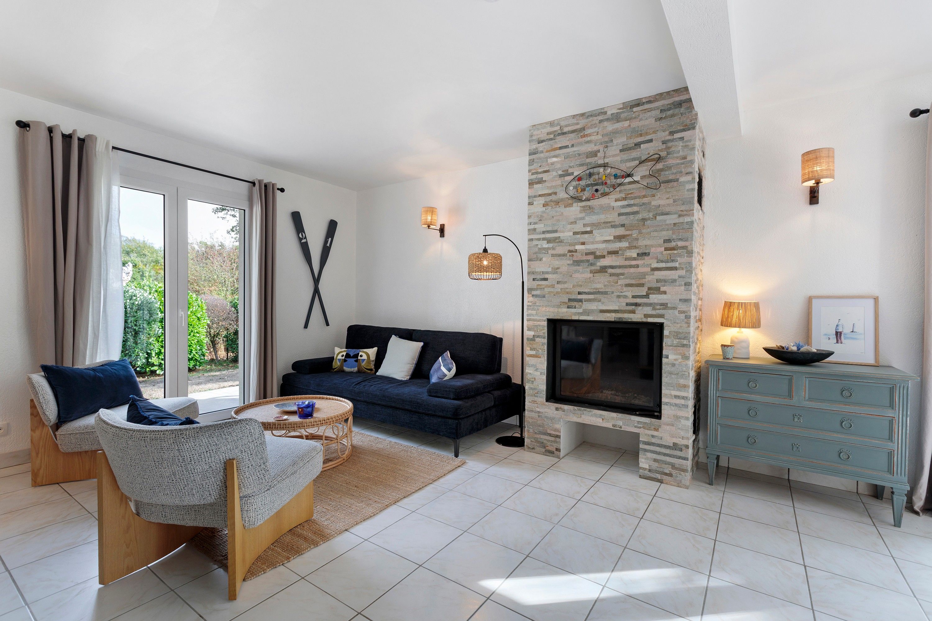 A living room with a stone fireplace, a sofa, a coffee table, and a TV.