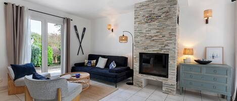 A living room with a stone fireplace, a sofa, a coffee table, and a TV.