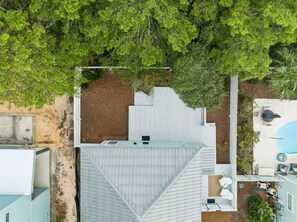 Ein Wohnhaus mit geneigtem Dach, umzäuntem Garten und Swimmingpool.