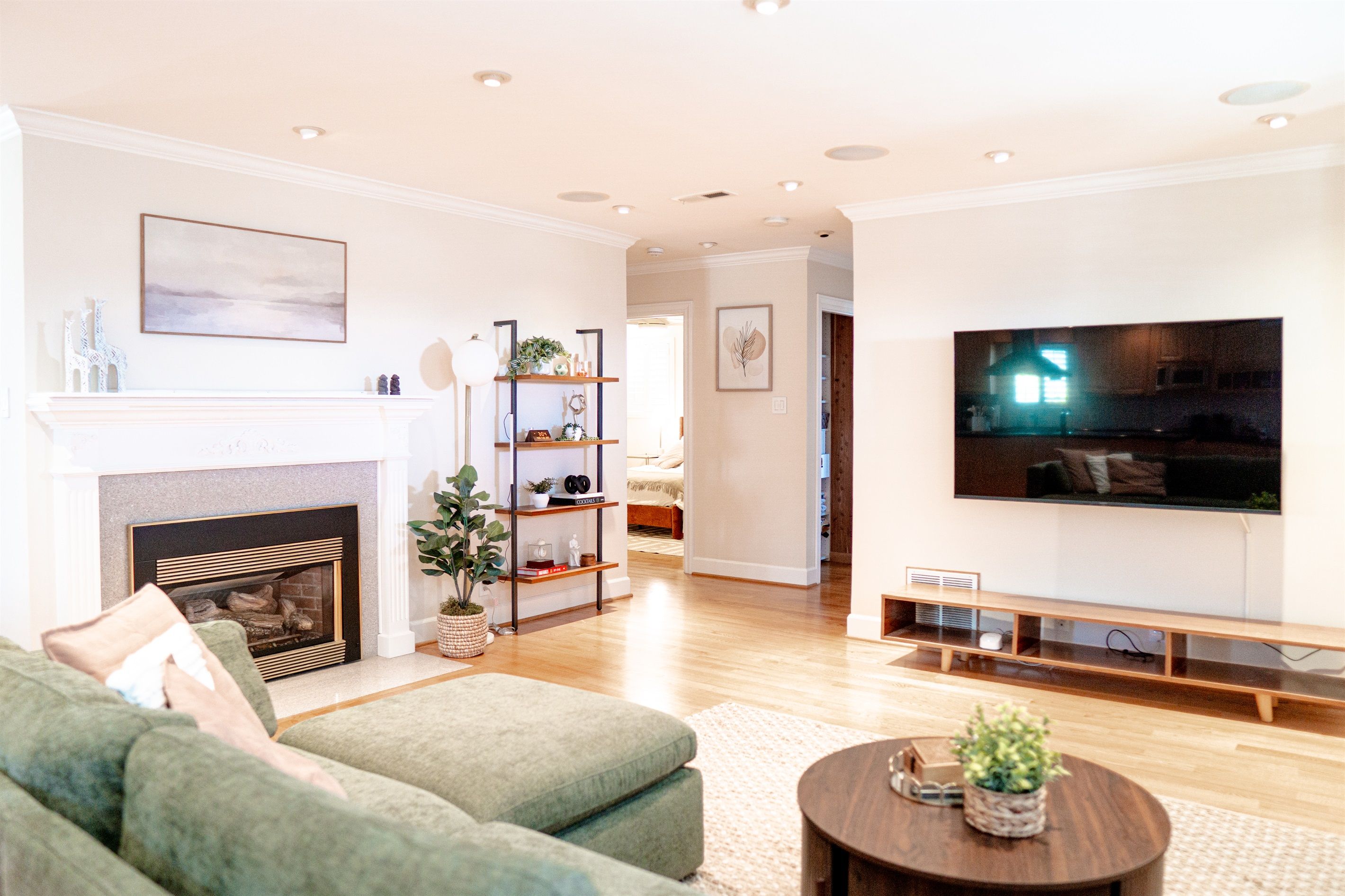 A spacious living room with a fireplace, a large flat-screen TV, and a comfortable seating area.