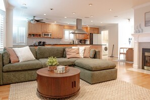 Ein modernes Wohnzimmer mit einem Ecksofa, einem Holztisch und einem Kamin.