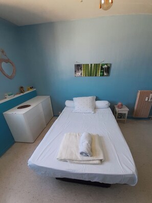 A bedroom with a bed, a bedside table, a dresser, and a wall-mounted picture. - Charming 1-bedroom apartment in Nice (Nice)