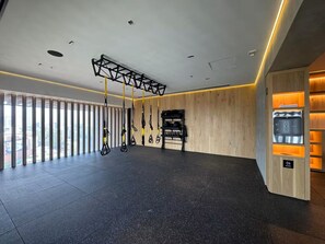 A spacious room with a black speckled floor, a wooden wall, and a ceiling with a geometric light fixture. - Aura 41 Un refugio sobre Reforma (Ciudad de México)