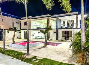 A modern two-story building with a pool, palm trees, and a well-maintained garden. - 10br Luxury Villa Private Pool (Sosúa)