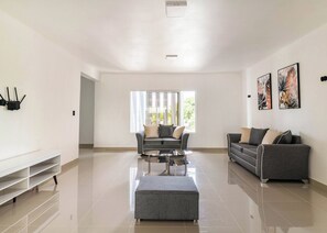 A spacious living room with a sofa set, a coffee table, and a white console table. - 10br Luxury Villa Private Pool (Sosúa)