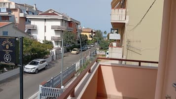 Een woonstraat met een balkon met uitzicht op de weg.