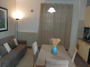 A living room with a sofa, a dining table with chairs, a blue vase, and a kitchen area with cabinets. - CASA MARINA GRANDE.
Siamo a 80m dal mare. Con 1 camera, 1 bagno e posto auto. (Montesilvano)