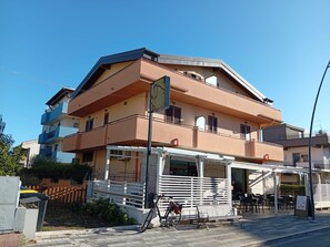 A multi-story building with a flat roof, balconies, and a covered outdoor seating area. - CASA MARINA GRANDE.
Siamo a 80m dal mare. Con 1 camera, 1 bagno e posto auto. (Montesilvano)