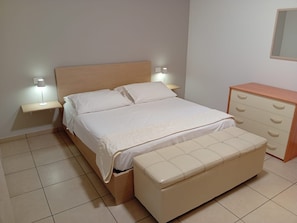 A bedroom with a bed, bedside tables, a dresser, and a bench. - CASA MARINA GRANDE.
Siamo a 80m dal mare. Con 1 camera, 1 bagno e posto auto. (Montesilvano)