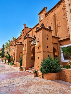 A traditional building with a courtyard, featuring arches, terracotta walls, and decorative elements. - auberge tissadrine (Ait Sedrate Jbel El Soufla)
